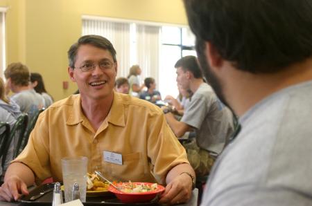 Troy Riggs, mathematics department chair, talks with an MK Isaac Evans during the Dinner with your Department event at New Student Orientation. - Photo by Stephanie Schroeder