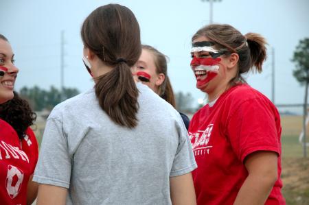 Sophomore Psychology Major April McCulley laughs with friends as they paint faces before a Lady Bulldog soccer match. - Photo by Matt Elia