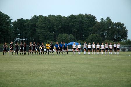 The Lady Bulldog soccer team (right) stands with the Bethel College team (left) during the national anthem. - Photo by Matt Elia