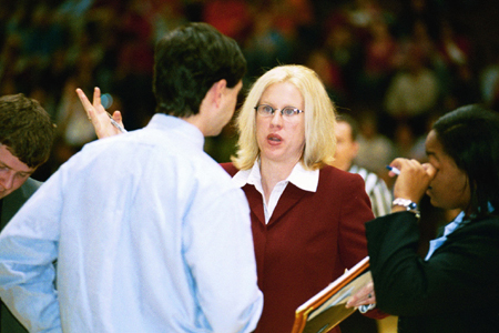 Head Coach Mark Campbell, Assistant Coach Katie Woodruff, and Graduate Assistants Tonya Tuggles and Brandon Wood go over strategy during a timeout. - Photo by Lindsay Stavish