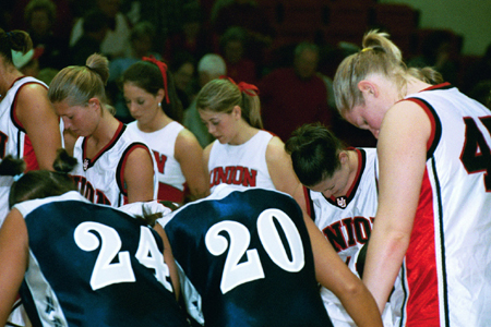 Players and cheerleaders from Union and Lambuth gather at mid-court for a post-game prayer. - Photo by Jim Veneman