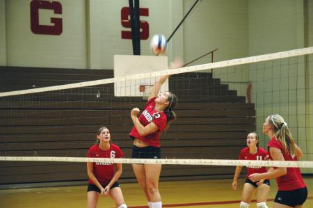 Freshman Jill Dake tips the volleyball over the net in the game against Mid-Continent University.  - Photo by Neisha Fuson