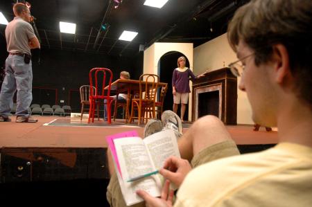 Junior Matt Stimmel sits off stage and follows along in his script as fellow Union students rehearse for <em>The Dining Room</em>, while director Chris Bennett (left) guides Senior Jill Casey in her scence. - Photo by Neisha Fuson