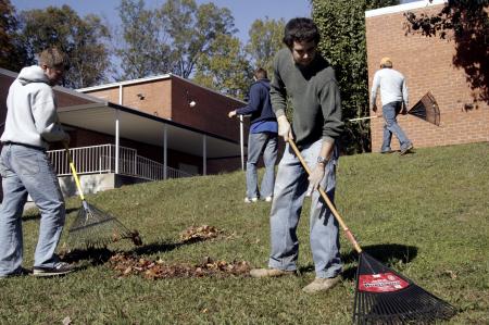 Josh Miller and Phillip Mitchell work with their SAE brothers to rake and pick up leaves at the Augustine School during the 2007 Day of Remembrance. - Photo by Kyle Kurlick
