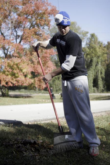 SAE Corbit Franks rakes leaves at the Augustine School during Day of Remembrance. - Photo by Kyle Kurlick