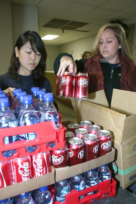 Sophomore Sarah Kim and Senior Carly Ford set out drinks with the lunches made for teams working at all day projects during Day of Remembrance. - Photo by Stephanie Schroeder