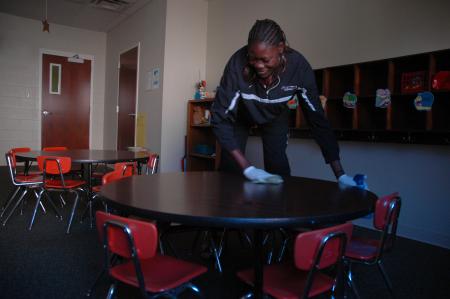 Freshman Lady Bulldog Beatrice Awino cleans some tables in J-Crib Ministries for this year's service project on Day of Remembrance.  - Photo by Neisha Fuson