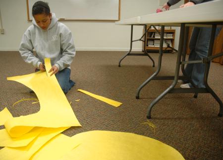 Sophomore Kimberly Middleton helped cut out some decorations during Day of Remembrance for J-Crib Ministries banquet, which this year, had a western theme.  - Photo by Neisha Fuson