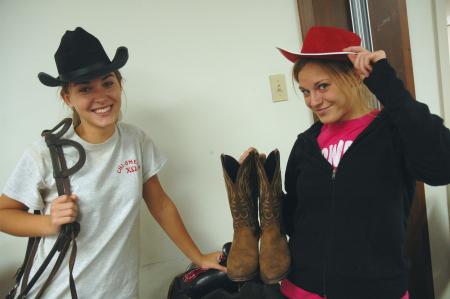 Sophomores Chanel Watson and Bethany Anderson play in the western gear to be used for decorations at the J-Crib Ministry during Day of Remembrance.  - Photo by Neisha Fuson