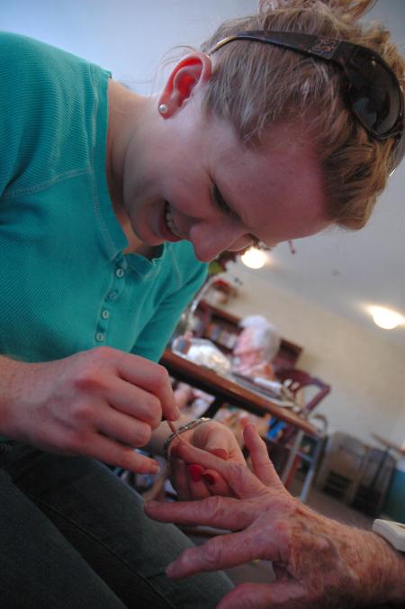 Junior Sarah Eastin painted some ladies' nails at Cheyenne Trace as a part of her volunteer work on this year's Day of Remembrance.  - Photo by Neisha Fuson