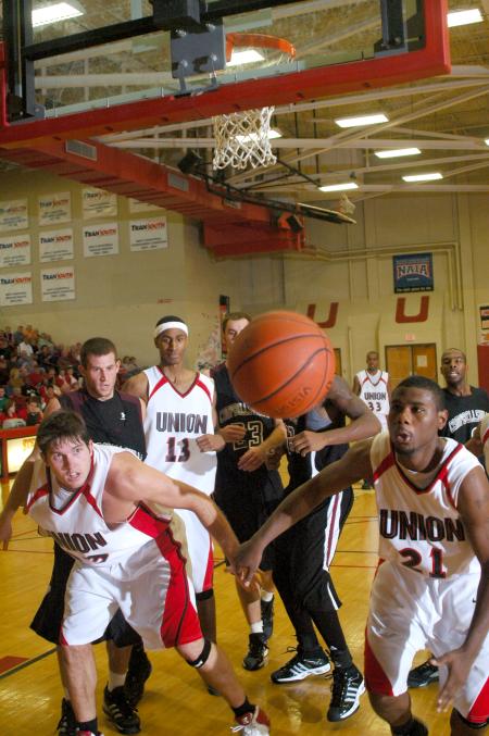 Senior Ryan Merriman (23) and junior Brian Lake (21) try to save a loose ball as it goes out of bounds.  - Photo by Matthew Diggs