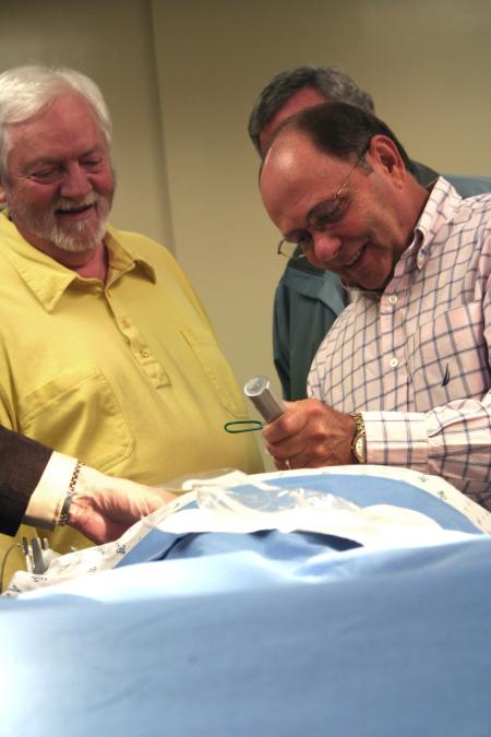 Alums were able to test the simulator mannequin under Mark Kossick's instruction at the School of Nursing's homecoming reception. - Photo by Kristi McMurry Woody