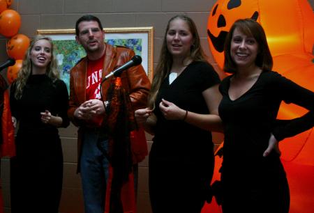 Dr. Keith Bates sings karaoke with Sophomores Elizabeth Wood, Alyssa Bantz and Jenny Hutcherson at the Hurt Costume Coffee House. - Photo by Stephanie Schroeder