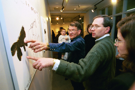 Artist Roger Sullivan points out a detail in his work at his artist's reception. - Photo by Jim Veneman