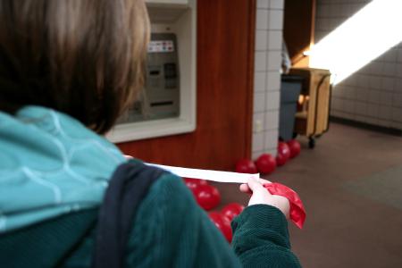 Sophomore Miranda Lindsey, education major, reads the sheet of paper that was inside of the balloon that she popped as a part of AIDS awareness week.  Students were encouraged to learn more about this deadly virus. - Photo by Kristi McMurry Woody