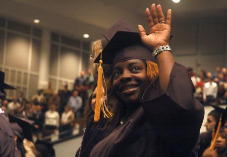 Tammy Q. Reed waves to family members during the Fall graduation ceremonies.   - Photo by Matthew Diggs