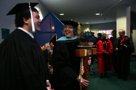 Josh Clarke and Dottie Myatt fellowship as they wait to begin the processional for the fall graduation ceremony. - Photo by Stephanie Schroeder