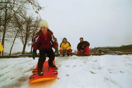 Dan and Stacie Herr watch as their son Caleb surfs on the snow during recent snow day. - Photo by Justin Veneman