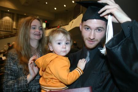 Alex Carr holds his nephew, Camden, as his mom stands behind him at fall graduation. - Photo by Stephanie Schroeder