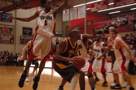 Sophomore Tacuma Alexander (3) leaps to block the ball from his Freed Hardeman opponent.  - Photo by Neisha Fuson