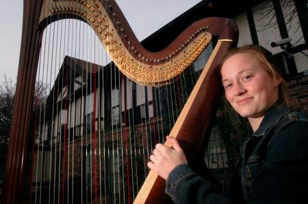 Anna Wicker displays her prized harp outside of its new home in The Jett. She now must store it in a separate room in The Jett and practices there. - Photo by Kyle Kurlick