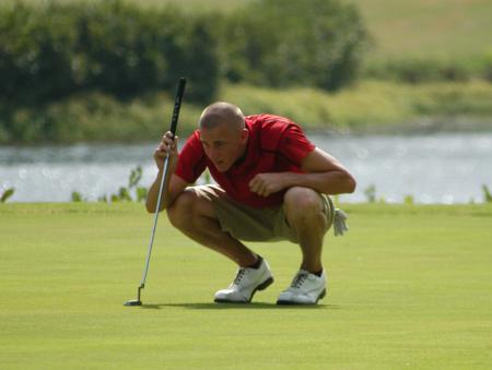 Clay Mallard lines up his put on the green. - Photo by Steven Aldridge