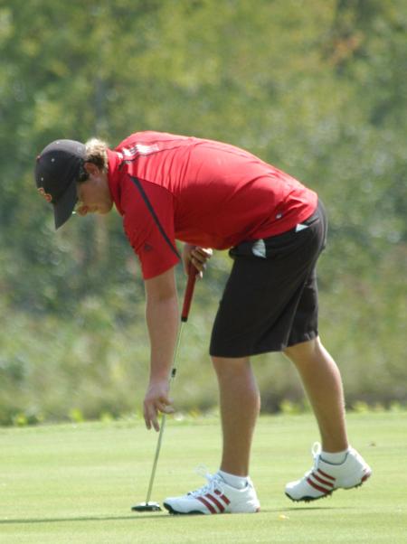 Brian Glover reaches down to get the ball from the cup after sinking a put. - Photo by Steven Aldridge