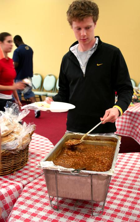 Brock Starnes, junior management major, gets a barbeque plate in Coburn.  The delicious barbeque lunch was provided and prepared by the team members at Gwatney Chevrolet in Memphis, TN.  - Photo by Kristi McMurry Woody