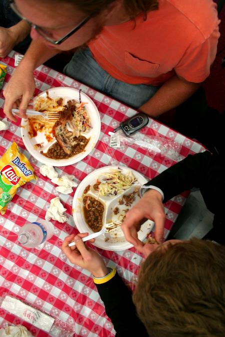 Mark Inman, senior art major, and Brock Starnes, junior management major, eat their barbeque plates in the Coburn dining hall.  The meal was provided and prepared by the team members at Gwatney Chevrolet in Memphis, TN. - Photo by Kristi McMurry Woody