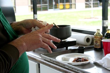 Russell Gwatney of Gwatney Chevrolet wipes his hands after preparing a sauce for the meat that he and his are team cooking.  The men of Gwatney Chevrolet prepared a wonderful barbeque lunch for Union University faculty, staff, and students. - Photo by Kristi McMurry Woody