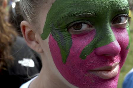 Sarah Patch paints a ZTA strawberry on her face to support her sorority during Greek Olympics. - Photo by Kyle Kurlick