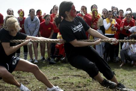 Bethany Anderson and Missy Ratliff pull with all their strength to win the tug-of-war competition while their Chi Omega sisters cheer for them. - Photo by Kyle Kurlick
