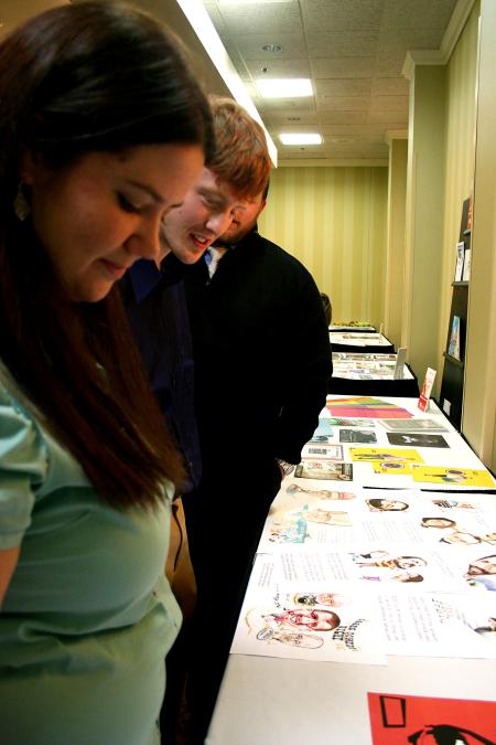 Kat Douglas, senior art major, and Alan Knox, senior DMS major, look at the graphic design work of people in the area at the annual Addy awards.  Both students won awards at this event. - Photo by Kristi McMurry Woody