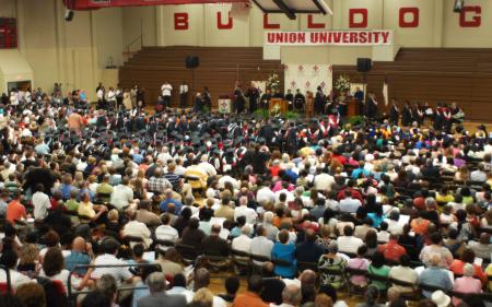 Graduates file across the stage in the Fred DeLay gymnasium during summer graduation. - Photo by Angela Abbamonte