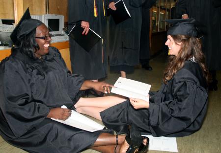 Organizational leadership graduates, Cassandra Hunt and Angela Tharpe, have a laugh before the graduation ceremony begins. - Photo by Kristi McMurry Woody