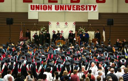 Summer graduates listen as President Dockery welcomes them to the ceremony.  This is the first time that graduation has been held in the Fred DeLay gymnasium. - Photo by Kristi McMurry Woody