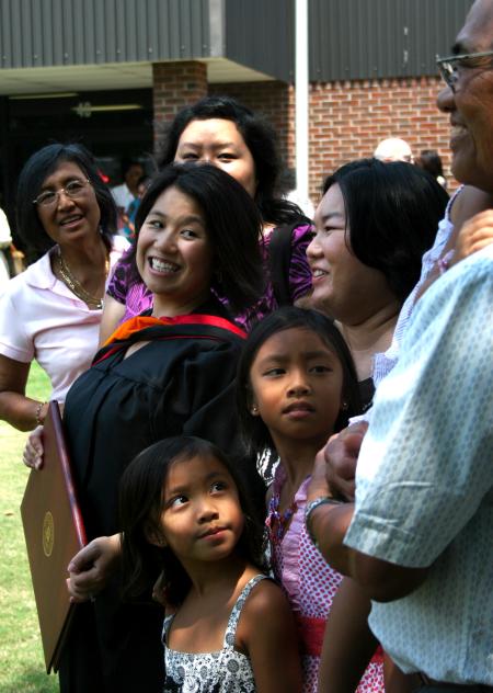 May Lee Almeria, who received her masters in nursing, spends time with her family from Tampa, Florida after the summer graduation ceremony. - Photo by Kristi McMurry Woody