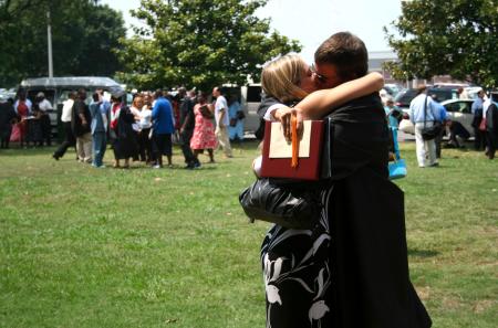 Richard Scott, who received his bachelor of science in organizational leadership, greets his wife, Erica, with a kiss after the summer graduation ceremony. - Photo by Kristi McMurry Woody