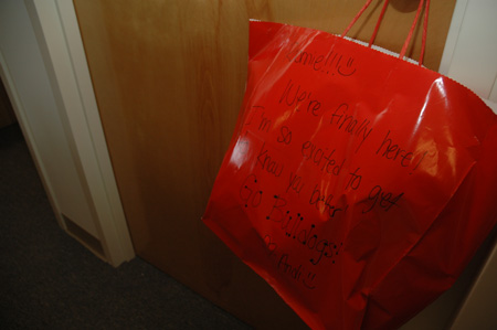 Freshman Andy Schreiber hangs a welcoming gift on her new roommate's door. - Photo by Beth Spain