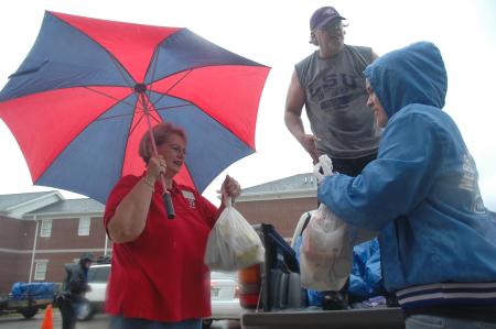 Though the rain beat harder, students and faculty were still persistent to unload trucks full of dorm furnishings. Here Nursing faculty member Sandra Brown helps bring in groceries. - Photo by Beth Spain
