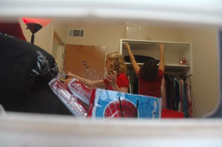 Freshman Brittany Johnson, overwhelmed with the number of students welcoming her to Union, continues to personalize her room as her mother sets up her curtains. - Photo by Beth Spain