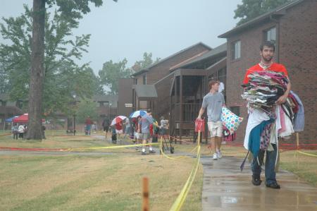 Senior Kieler Henry carries a load of clothes to a girl's dorm during Freshmen move-in day.  - Photo by Beth Spain