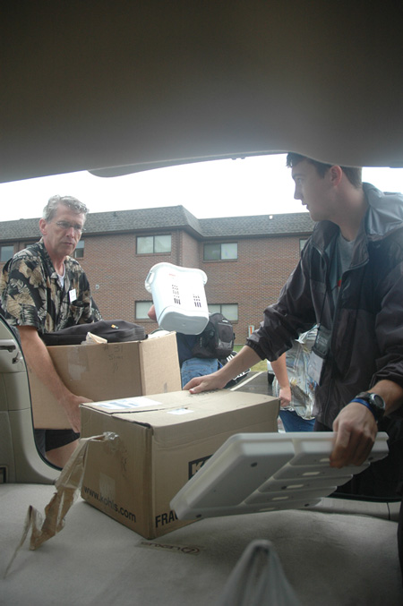 Richard Wells, dean of the chapel, and Junior Peter Boedecker unload a student's belongings during freshmen move-in day.  - Photo by Beth Spain