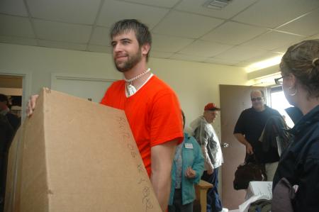 Senior Kieler Henry carries boxes of freshmen belongings during move-in day. - Photo by Beth Spain