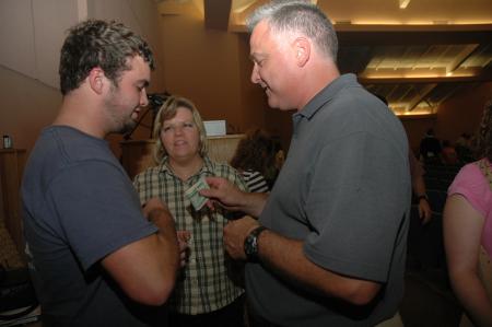 Eric Former acts upon President Dockery's advice and gives his son Jordan some extra spending money before heading home to Elkhart, Ind. after the Focus evening worship service.  - Photo by Beth Spain