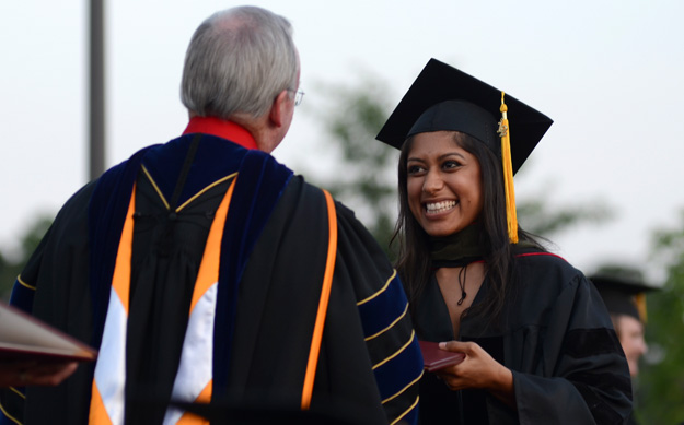 Keta Patel receives her doctor of pharmacy degree from David S. Dockery, president of the university, during spring graduation.