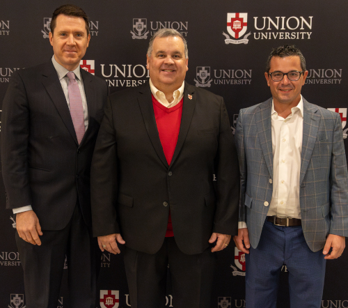 Three men stand side by side in business attire in front of a backdrop with the Union University logo and text, smiling at the camera. They are being introduced as new members of the trustees.