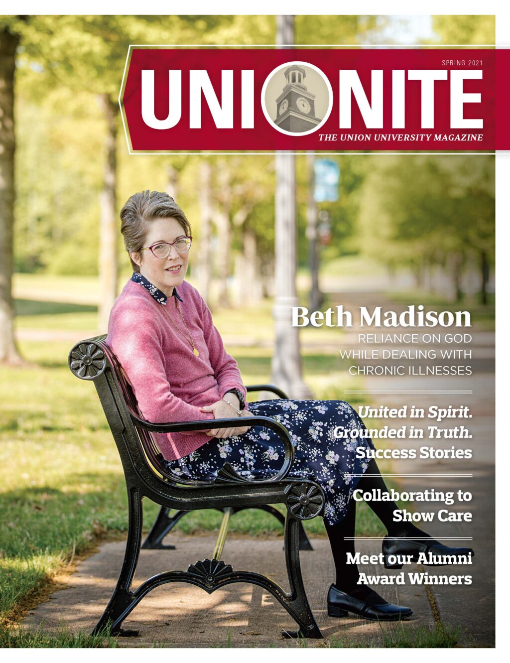 A woman with short gray hair and glasses, wearing a pink cardigan and floral dress, sits on a bench in a park. The magazine cover headline reads UNIONITE: The Union University Magazine.