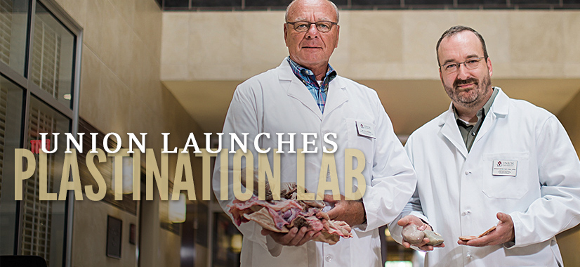 Two men in white lab coats stand indoors, one holding preserved organs and the other a small object. Large text reads, Union launches the first plastination lab in the United States.