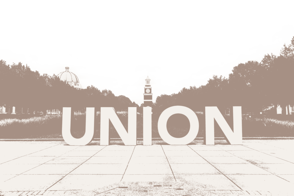 Large block letters spelling “UNION” stand on a paved walkway, with a clock tower and a dome-shaped building visible in the background, surrounded by trees. The image is in a sepia-toned, high-contrast style.